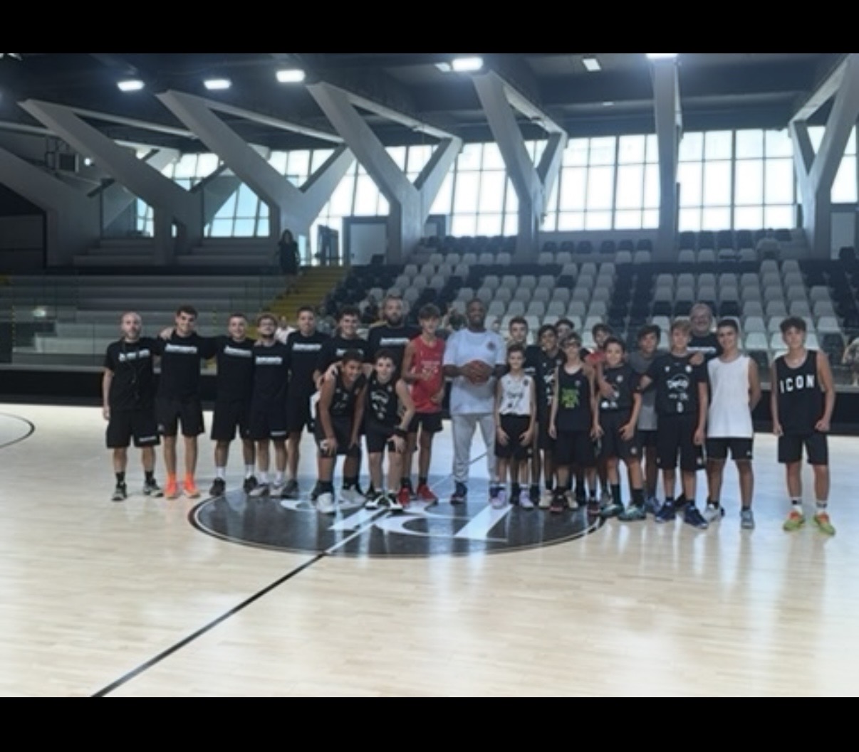 Youth players and coaches gather on court at the Italy camp